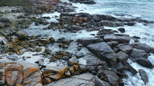 Aerial shot above a  section of the Orange coloured boulders of the Bay of Fires photo