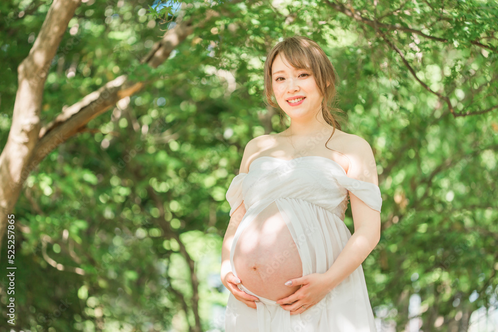 マタニティフォトの撮影をするアジア人妊婦の女性(木漏れ日)
マタニティフォトの撮影をするアジア人妊婦の女性(木漏れ日)