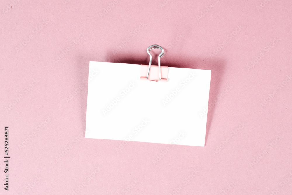 Blank white paper with a paperclip on a pink colored background, copy space for text, reminder or message in the office, communication concept Blank white paper with a paperclip on a pink colored background, copy space for text, reminder or message in the office, communication concept