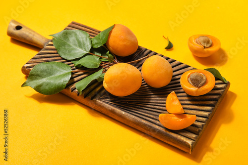 Wooden board with ripe apri...