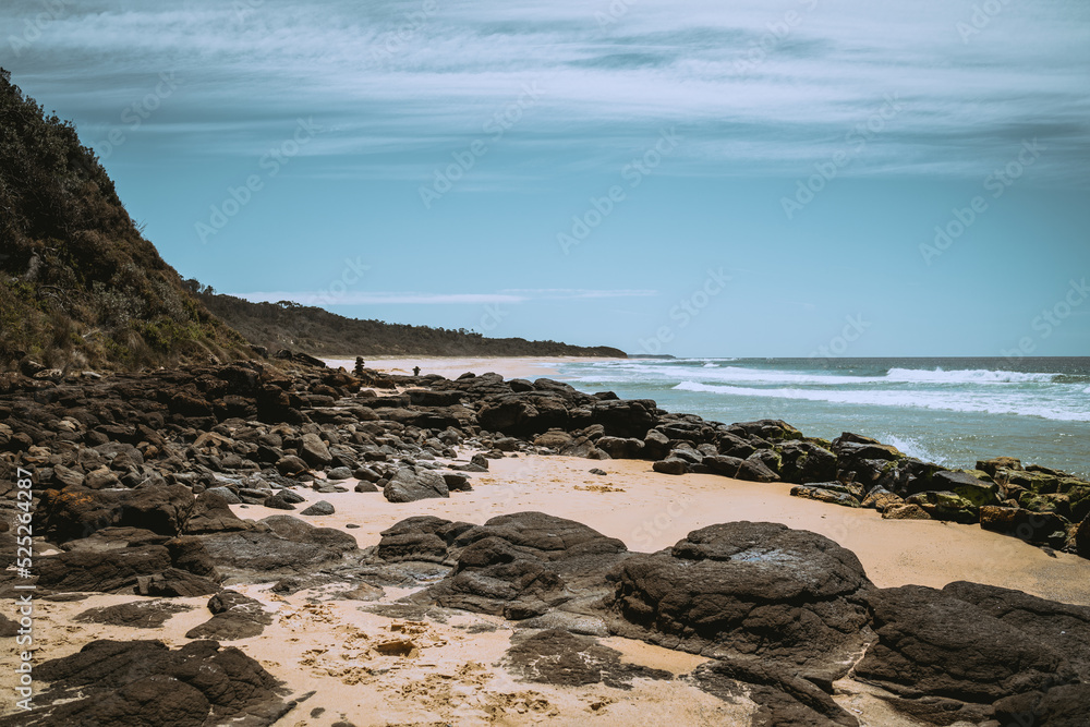 Rocks on Australian beach with blue sky