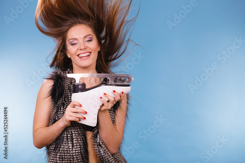 Papier peint Woman with windblown hair holding ice skate