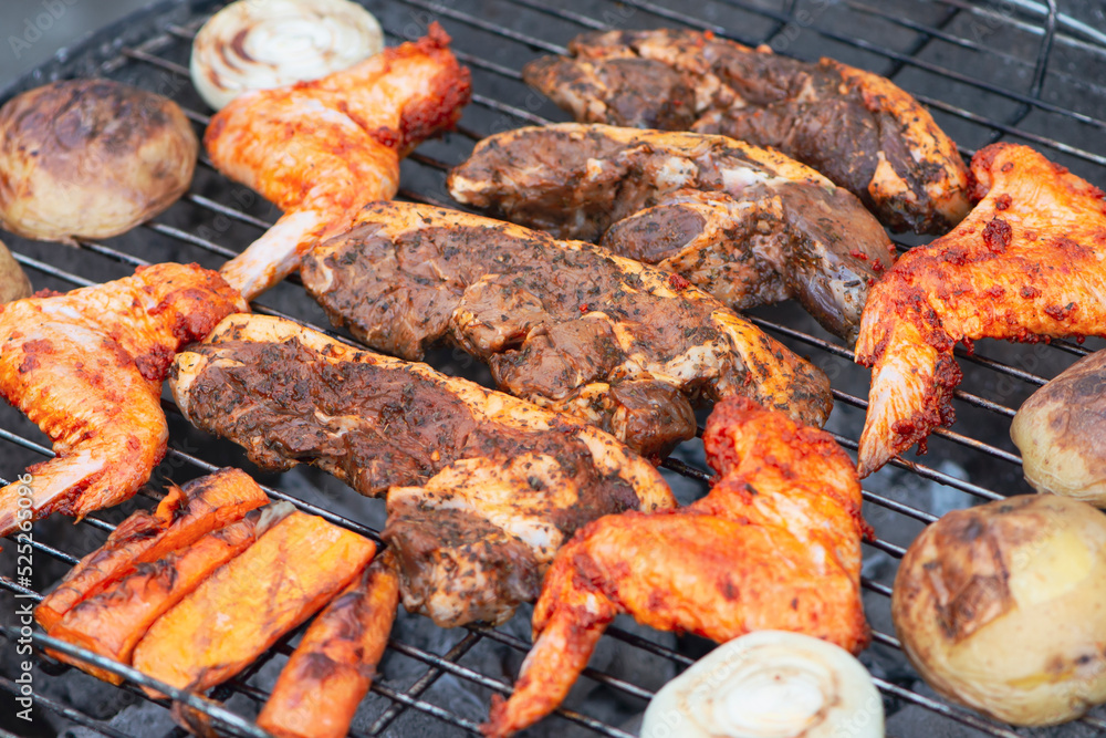 beef marinated steaks and chicken wings are cooked on the grill, barbecue