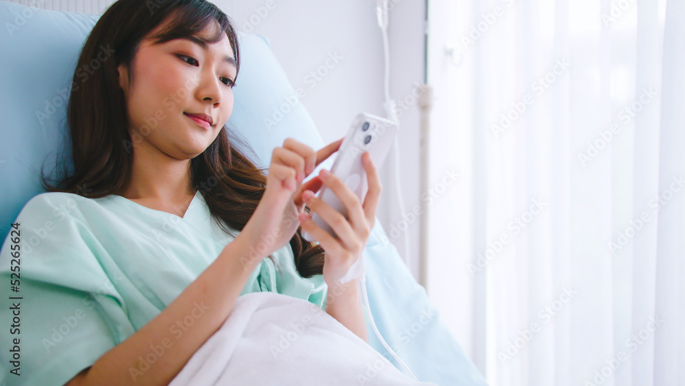 Young patient woman working on mobile phone while recovering in hospital. Young patient woman working on mobile phone while recovering in hospital.