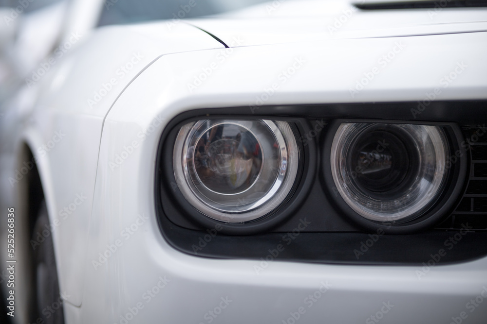 Close up of headlight detail of modern luxury sports car. Concept of car detailing and paint protection background.