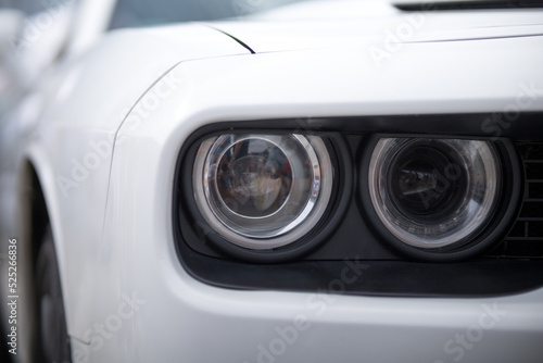 Close up of headlight detail of modern luxury sports car. Concept of car detailing and paint protection background. © Евгений Бордовский