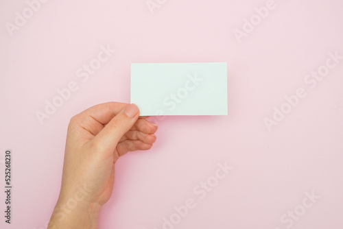  Woman holding blank business card., blank menu, discount card, business card on pink background. White Paper Card for Mockup. Mockup Design Template.
