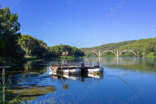 A boat with which people used to cross the river before the construction of bridges, with the railroad bridge. © Victor Griso