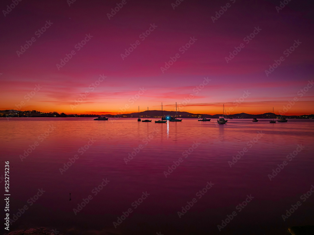 Pink dawn with boats and high cloud
