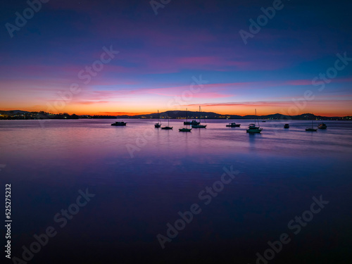 Colours of Dawn over the bay with boats and high cloud © Merrillie