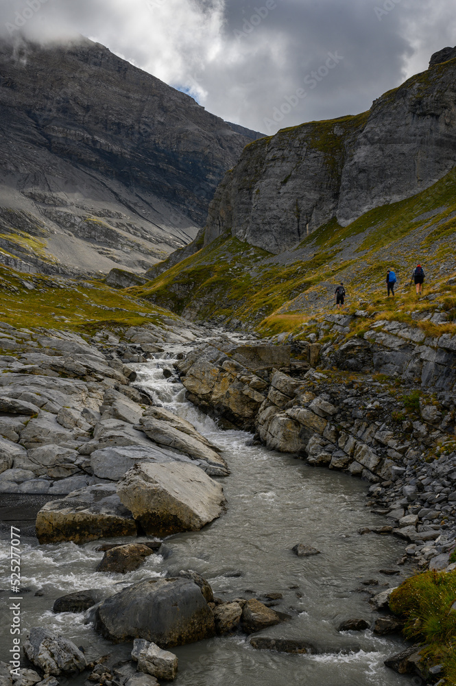 alpine hikers near mountain creek on Gemmi Pass in Valais