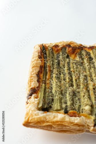 Baked puff pastry pie with cheese and asparagus on a white background, top view, copy space