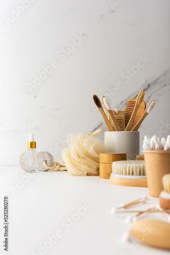 Wooden toothbrushes with natural bristles in a ceramic glass  face and skin care products  bath accessories  spa and beauty concept