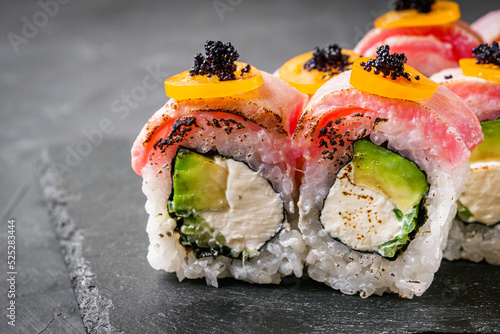 Fotografia delicious sushi rolls on a black stone background
