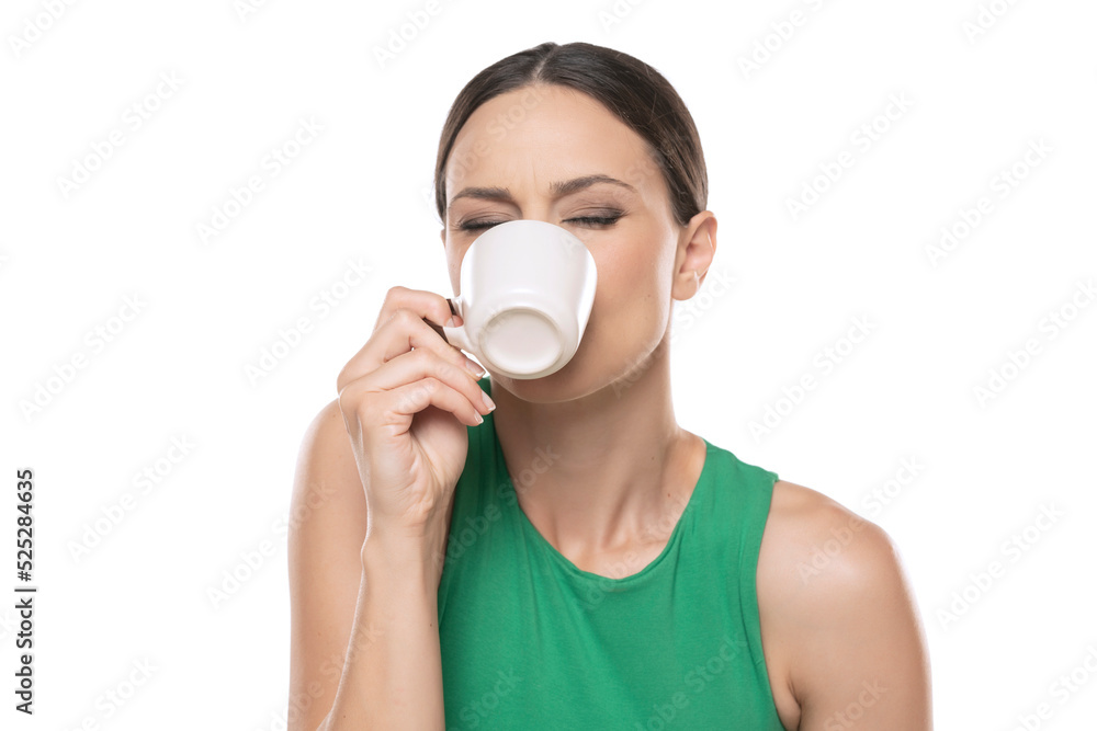 Joyful young woman with cup of hot beverage on a white background. Joyful young woman with cup of hot beverage on a white background.