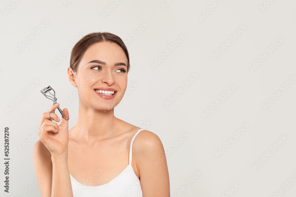 Woman with eyelash curler on white background, space for text Woman with eyelash curler on white background, space for text