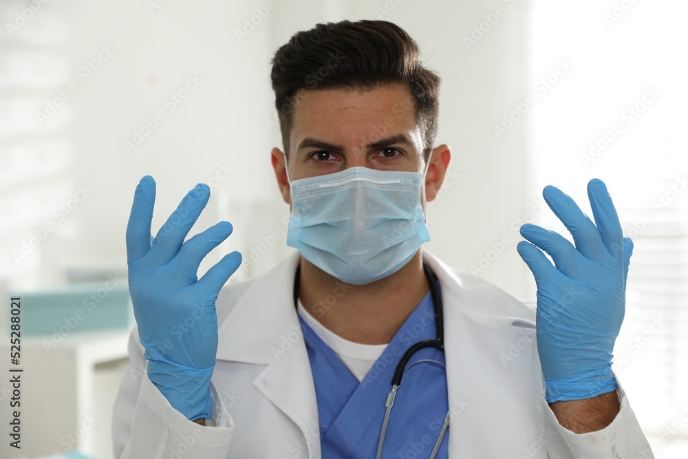 Doctor in protective mask and medical gloves against blurred background Doctor in protective mask and medical gloves against blurred background