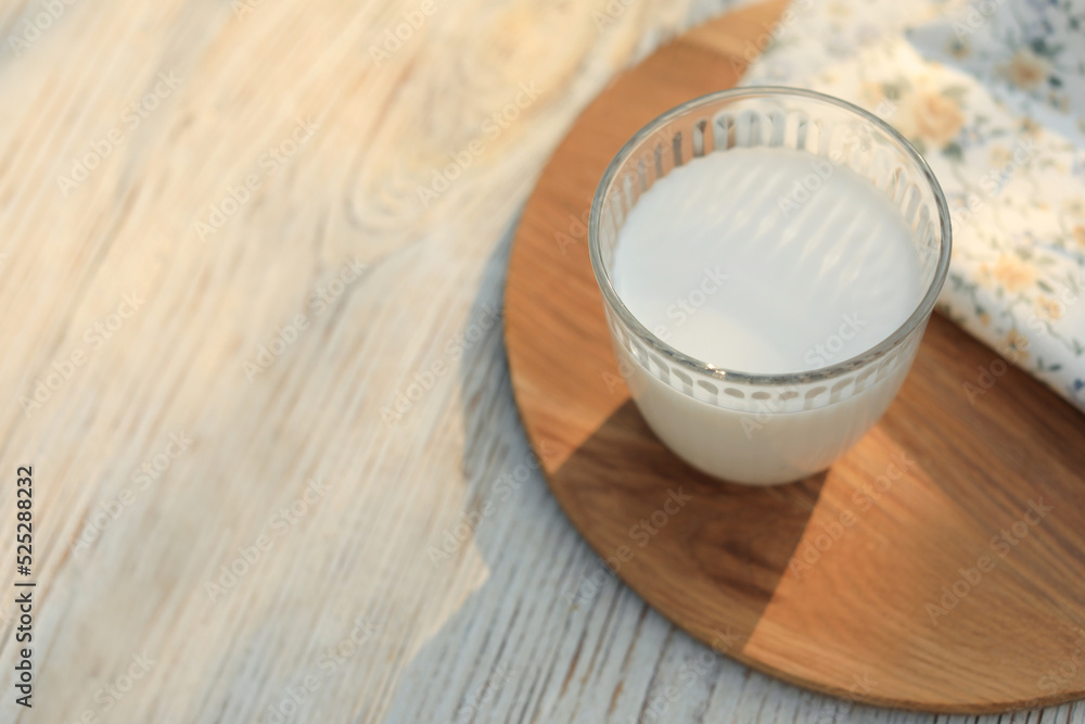 Glass of tasty fresh milk on white wooden table, above view. Space for text Glass of tasty fresh milk on white wooden table, above view. Space for text