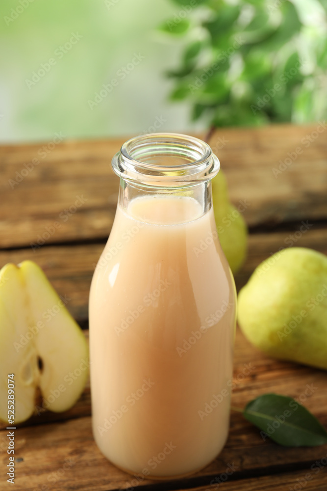 Fresh pear juice in glass bottle and fruits on wooden table, closeup Fresh pear juice in glass bottle and fruits on wooden table, closeup