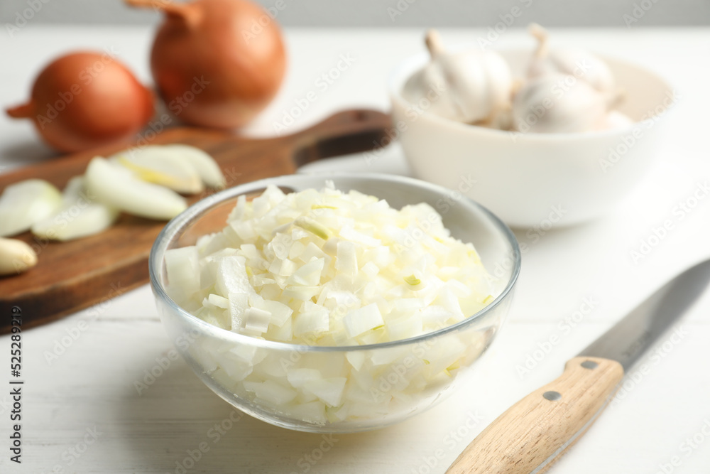 Chopped onion in bowl on white wooden table Chopped onion in bowl on white wooden table