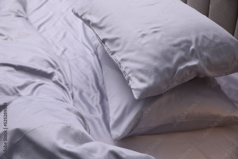 Cozy bed with soft silky bedclothes, closeup