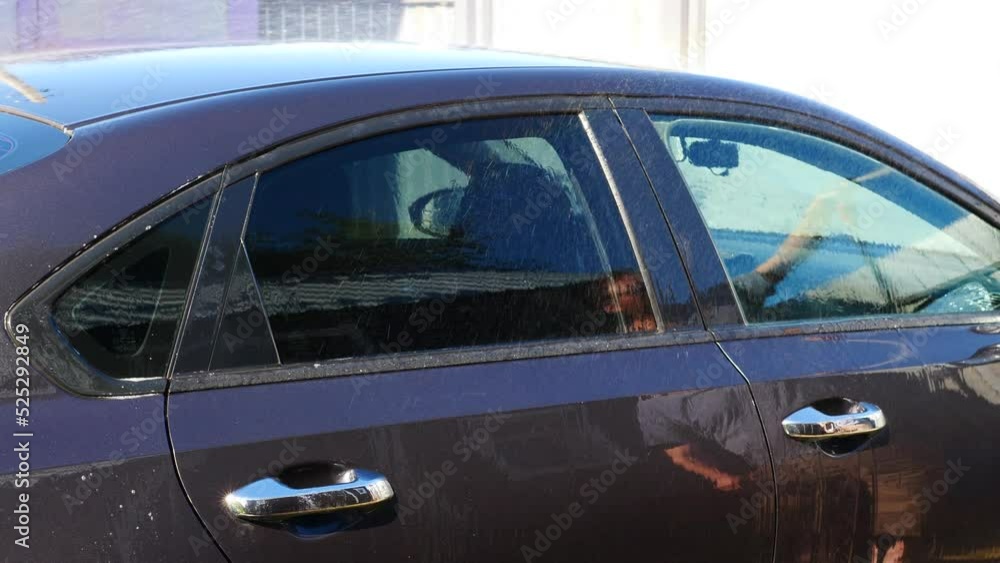 washing a car at a self-service car wash concept. rainbow from sunlight when washing a car on a summer day. hand washing a car outside washing a car at a self-service car wash concept. rainbow from sunlight when washing a car on a summer day. hand washing a car outside