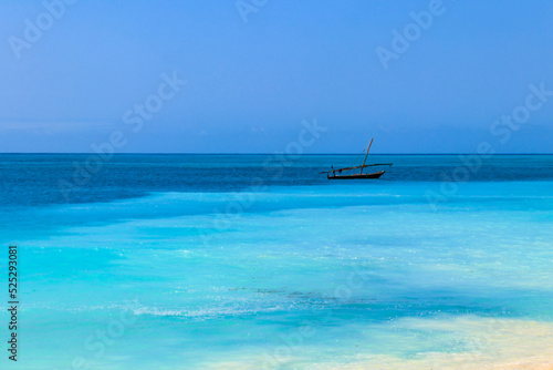 View of tropical sandy Nungwi beach and traditional wooden dhow boat in the Indian ocean on Zanzibar, Tanzania