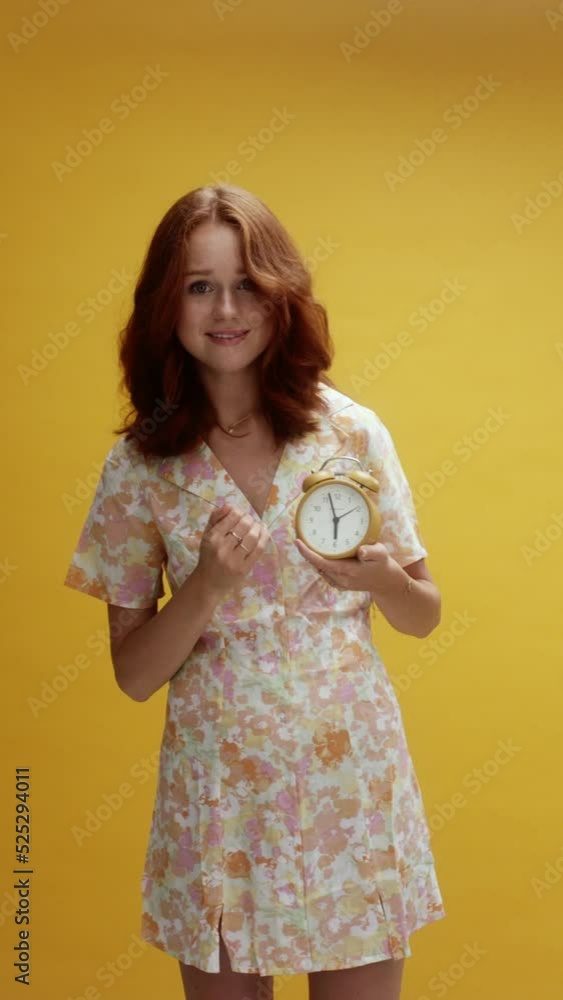 A young white ginger on yellow background pointing at the clock, hurry up A young white ginger on yellow background pointing at the clock, hurry up
