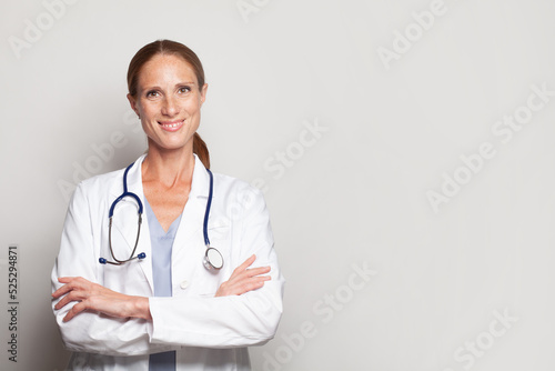 Friendly woman doctor in white uniform smiling looking at camera