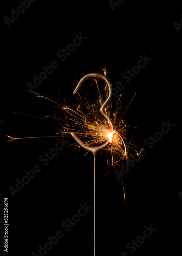 Burning golden sparkler in shape of number three  digit 3  isolated on black background