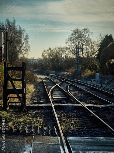 The view across a level crossing from a small, somewhat melancholy and wistful rural train station on a cold, frosty and crisp winter morning.
