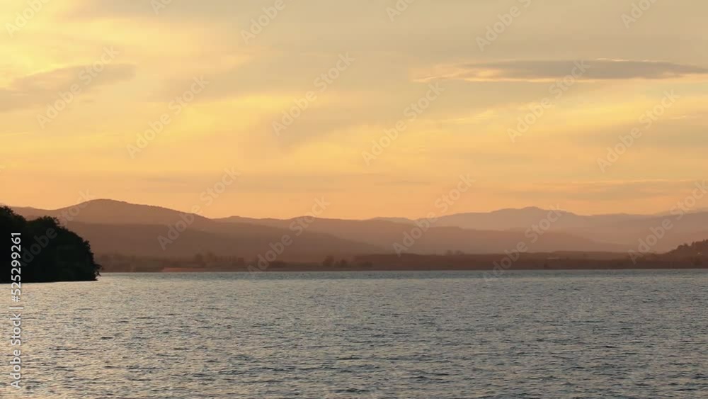 Beautiful sunset landscape from the lake with mountains in background Beautiful sunset landscape from the lake with mountains in background