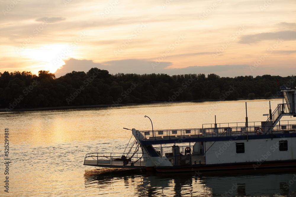 Ferry on the Danube river in Hungary during sunset.Summer season.