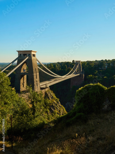 The famous Clifton Suspension Bridge at Bristol in dramatic side-lighting from a setting summer sun. photo