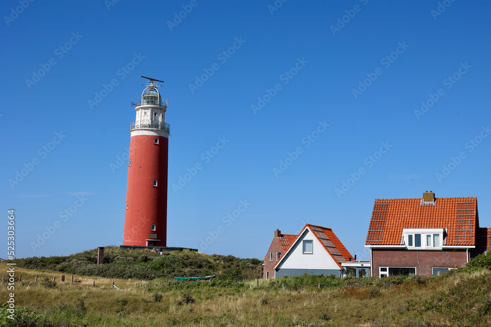 Red lighthouse in the typical Dutch village on Texel Island in the Netherlands. Red lighthouse in the typical Dutch village on Texel Island in the Netherlands.