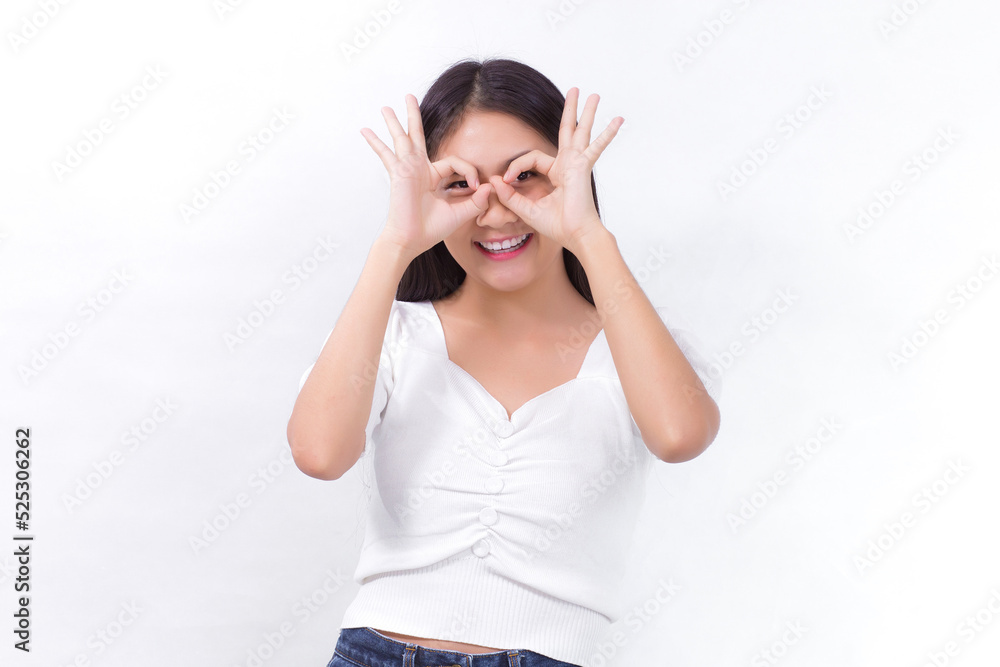 Asian female with long black hair wears white shirt and shows hand “okey” sign on white background. Asian female with long black hair wears white shirt and shows hand “okey” sign on white background.