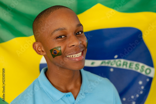 Portrait of happy african american male teenager with flag of brazil