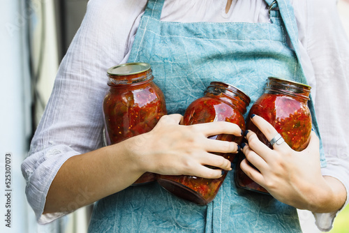 Obraz na plátně Woman's hands holding homemade canned quart mason jars of tomato salsa