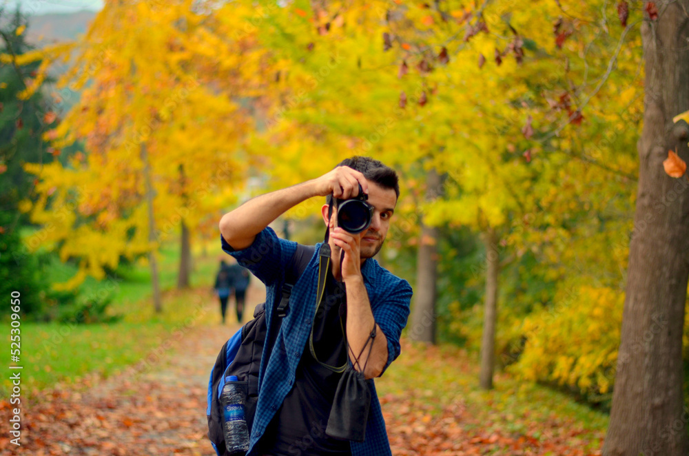 Male photographer in the forest. A traveling photographer in autumn colors.

