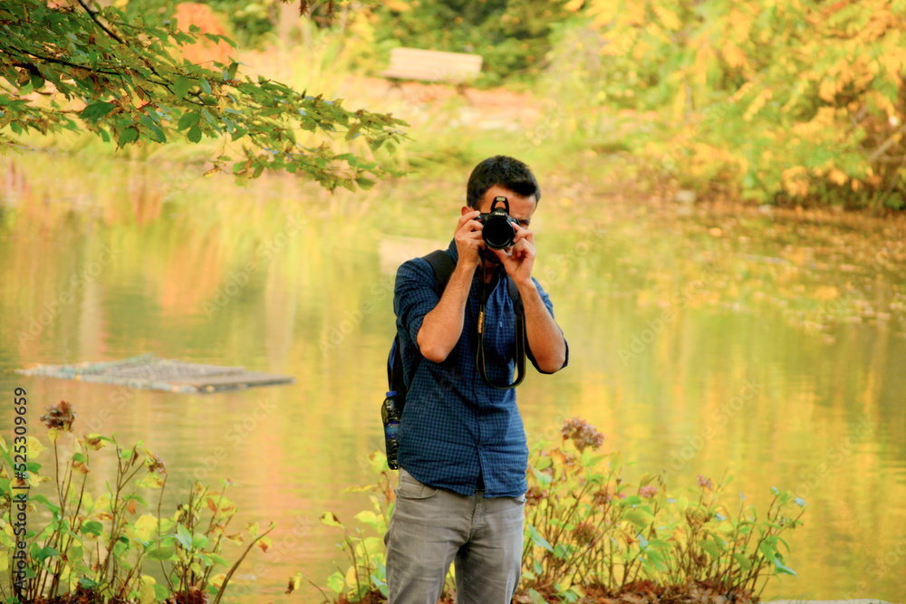 Obraz premium Male photographer in the forest. A traveling photographer in autumn colors. 