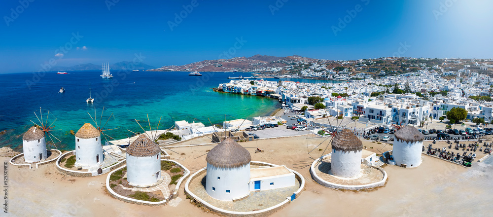 Fototapeta premium Panoramic view through the famous windmills above Mykonos town, Cyclades, Greece, to the Little Venice district