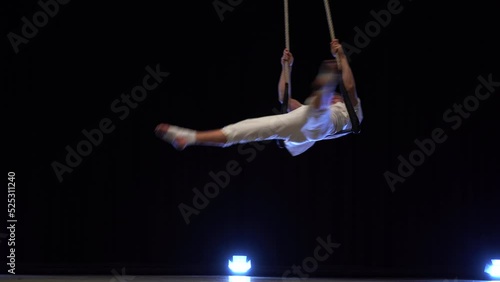 Muscular male air circus artist performances with dance trapeze 