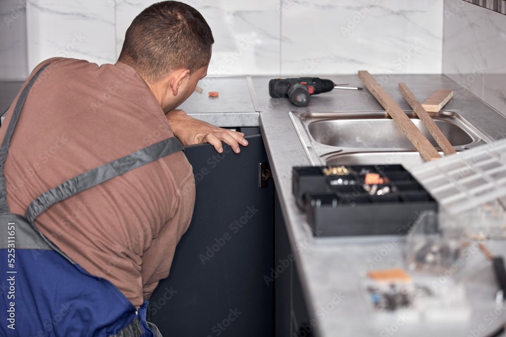 Handyman making kitchen wall cabinets in the apartment. Handyman making kitchen wall cabinets in the apartment.