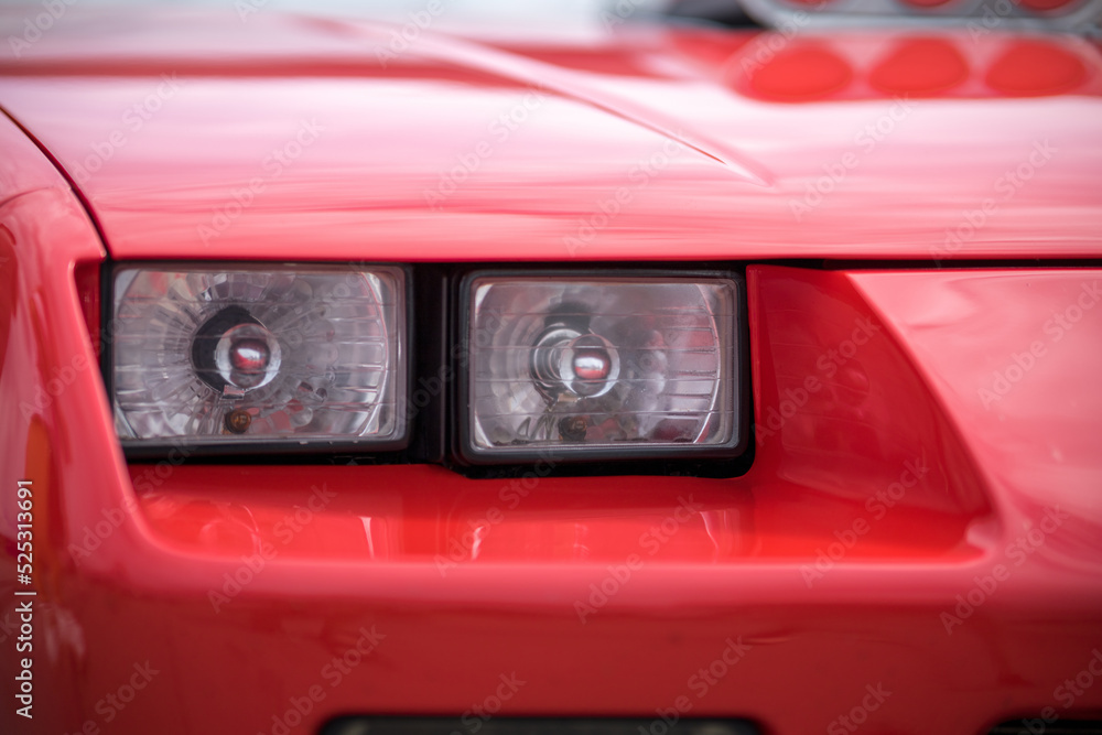 Close-up of the headlights of a red vintage car