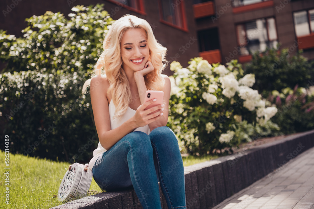 Photo of sweet pretty young curly girl dressed white singlet typing modern gadget enjoying sunny weather outdoors countryside Photo of sweet pretty young curly girl dressed white singlet typing modern gadget enjoying sunny weather outdoors countryside