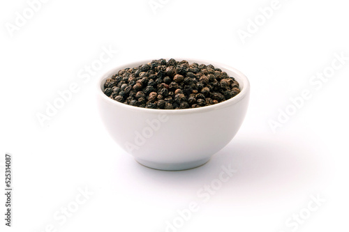 Black pepper or peppercorns in ceramic bowl isolated on white background.