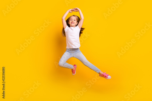 Full length photo of funky sweet schoolgirl dressed white t-shirt dancing jumping high isolated yellow color background