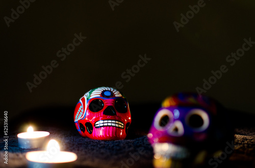 Calaveras mexicanas sobre fondo negro y luz de velas