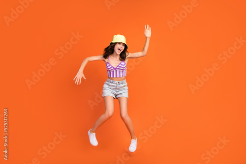 Full body photo of brunette crazy lady dance wear cap top shorts shoes isolated on orange color background