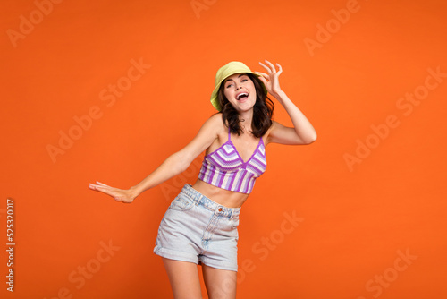 Photo of charming dreamy lady purple swimwear smiling dancing isolated orange color background © deagreez